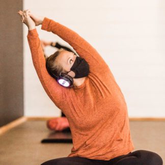 Yogi practicing a pose while wearing silent disco headphones