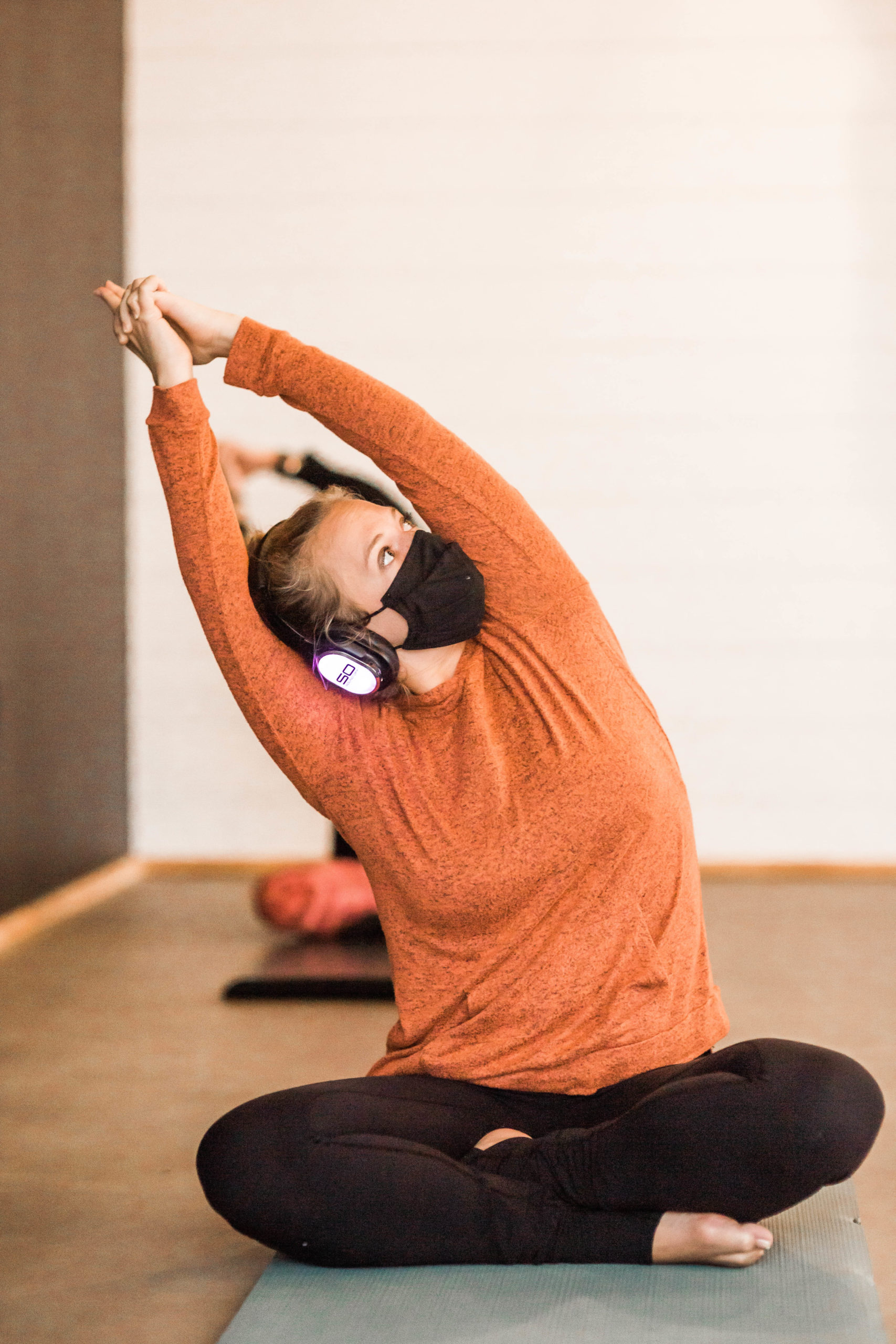 Yogi practicing a pose while wearing silent disco headphones
