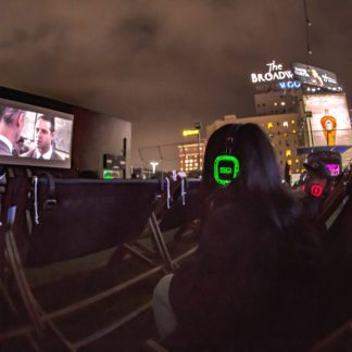 Audience watching a film outdoors with Sound Off headphones