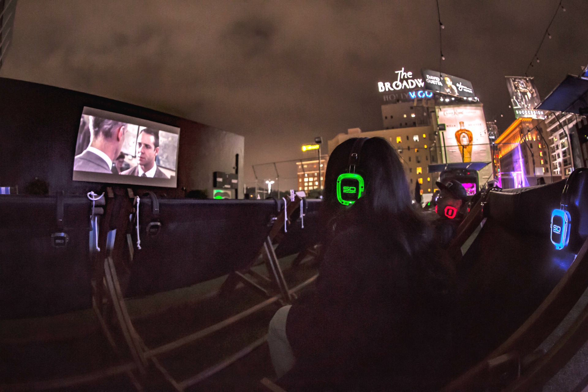 Audience watching a film outdoors with Sound Off headphones