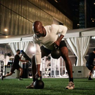 Man doing weight training at outdoor Equinox gym