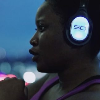 Woman wearing silent disco headphones in a Warrior Flow class