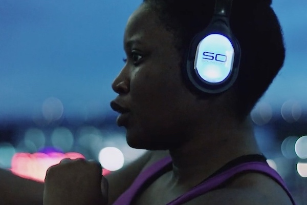 Woman wearing silent disco headphones in a Warrior Flow class