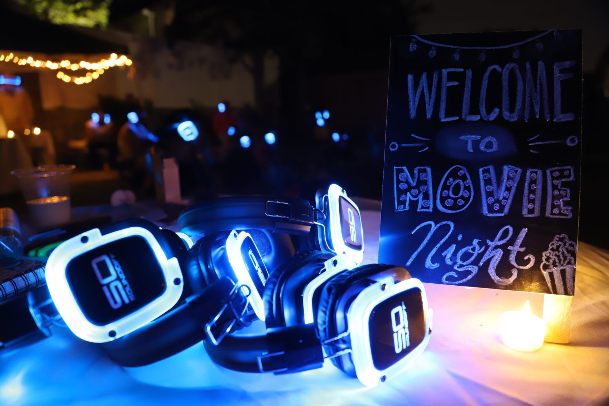 Glowing Sound Off headphones next to movie night sign