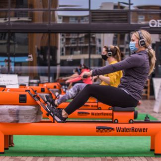 Women on rowing machine wearing Sound Off headphones