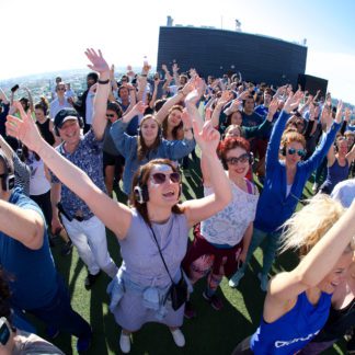 Outdoor crowd wearing headphones at a sober silent disco party