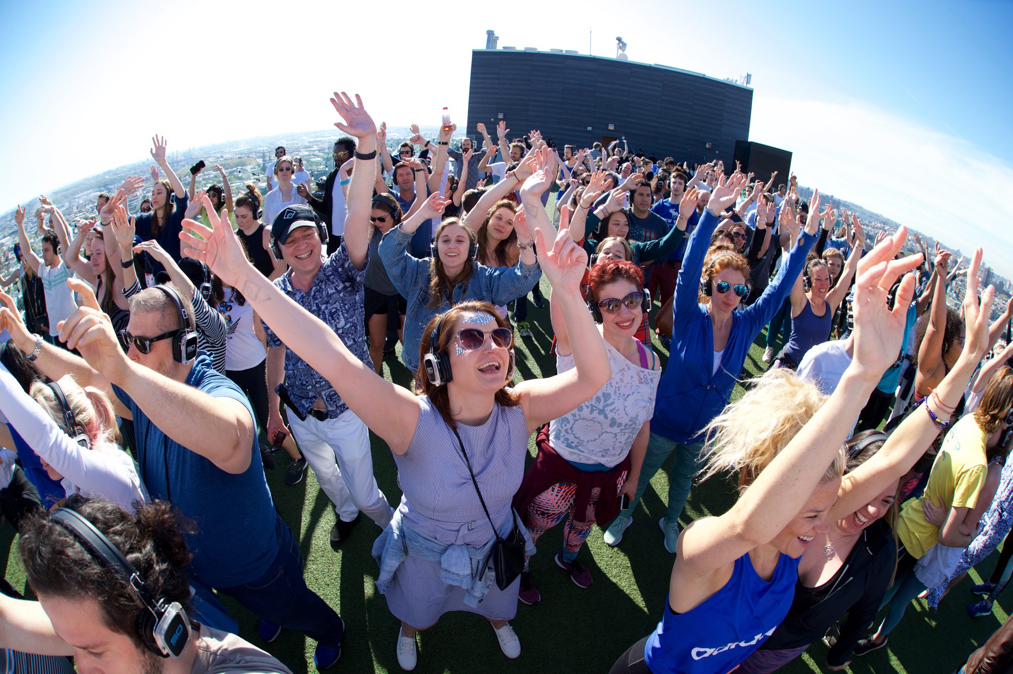 Outdoor crowd wearing headphones at a sober silent disco party