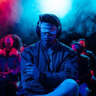 Man wearing silent disco headphones and blindfold at a theater production