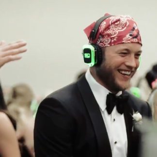 Laughing groom wearing Sound Off headphones at a silent disco wedding after-party