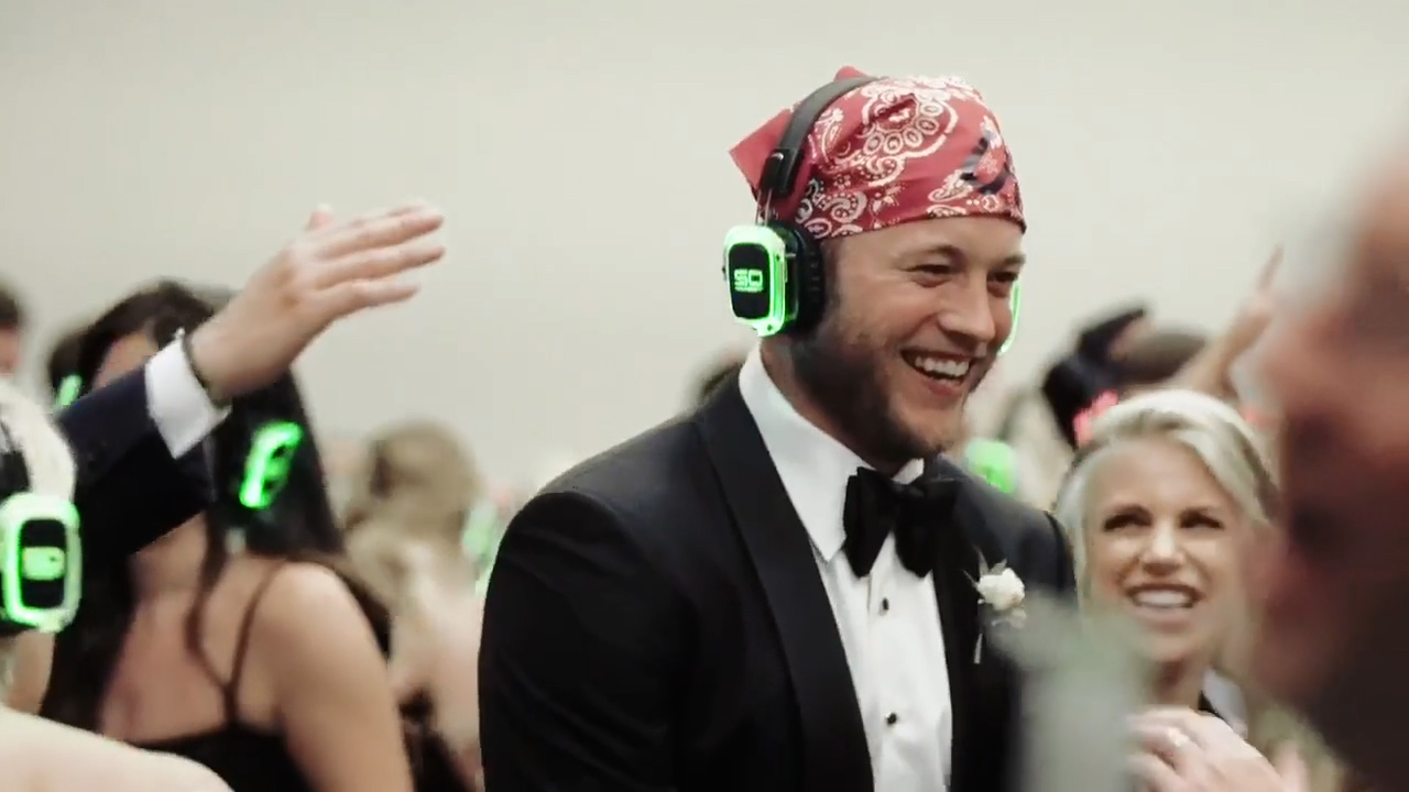 Laughing groom wearing Sound Off headphones at a silent disco wedding after-party