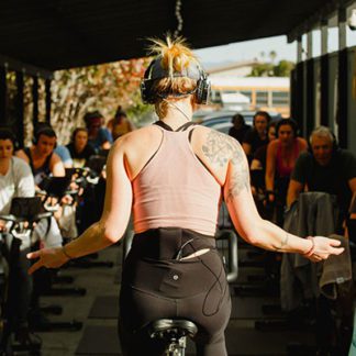 Instructor and students wearing Sound Off headphones at a GOAT Santa Cruz spin class