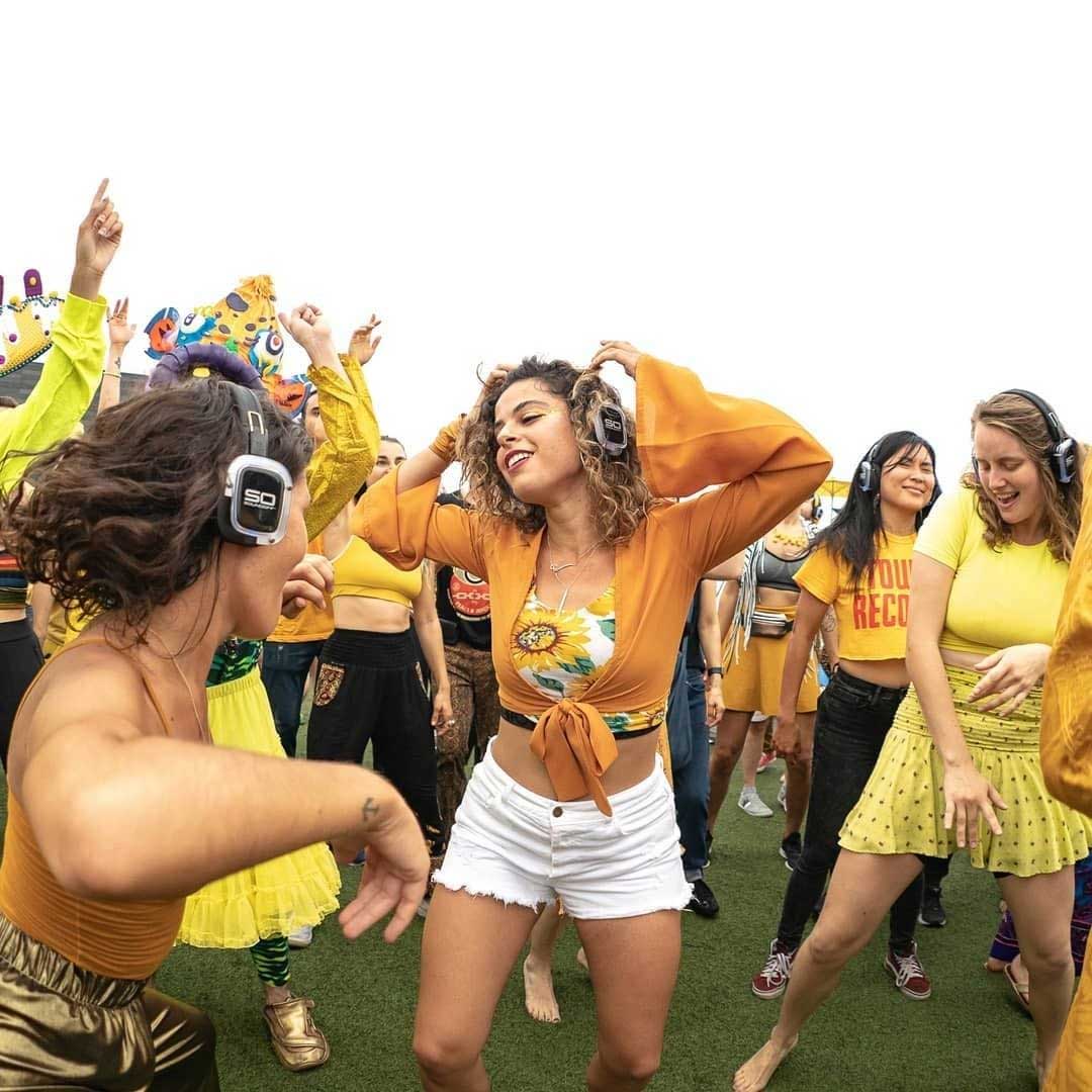 Women dancing outside wearing Sound Off silent disco headphones