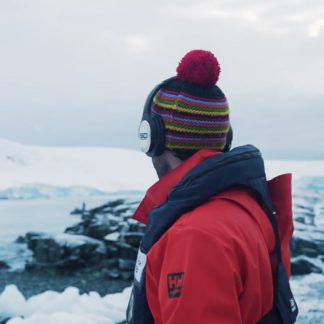 Man surveying the Antarctica landscape with silent disco headphones