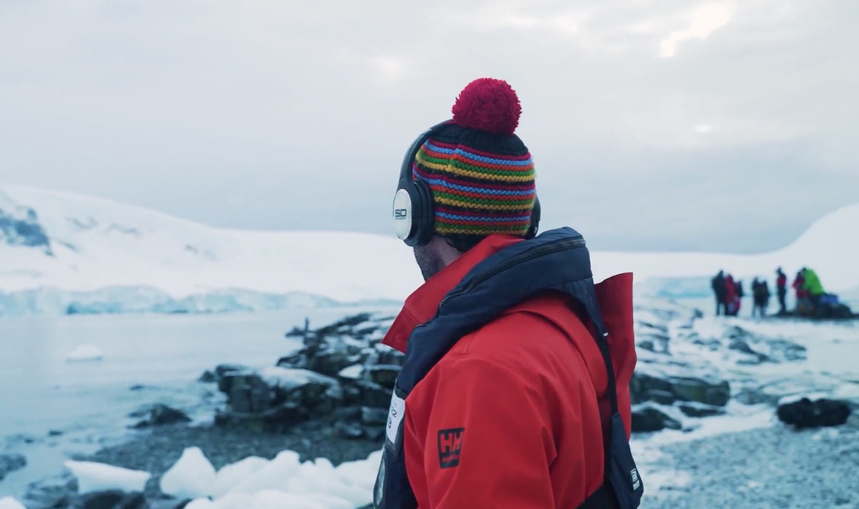 Man surveying the Antarctica landscape with silent disco headphones