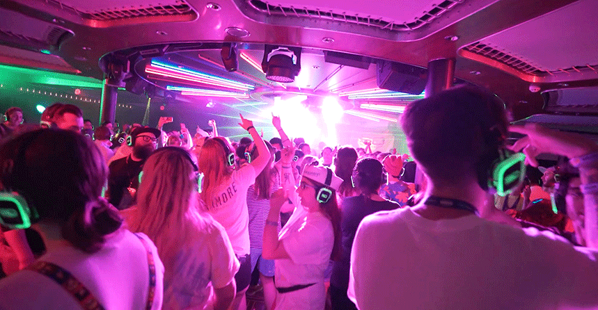 Passengers dancing at a silent disco cruise on the high seas